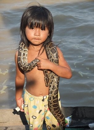 小女孩身缠巨蛇向游客乞讨